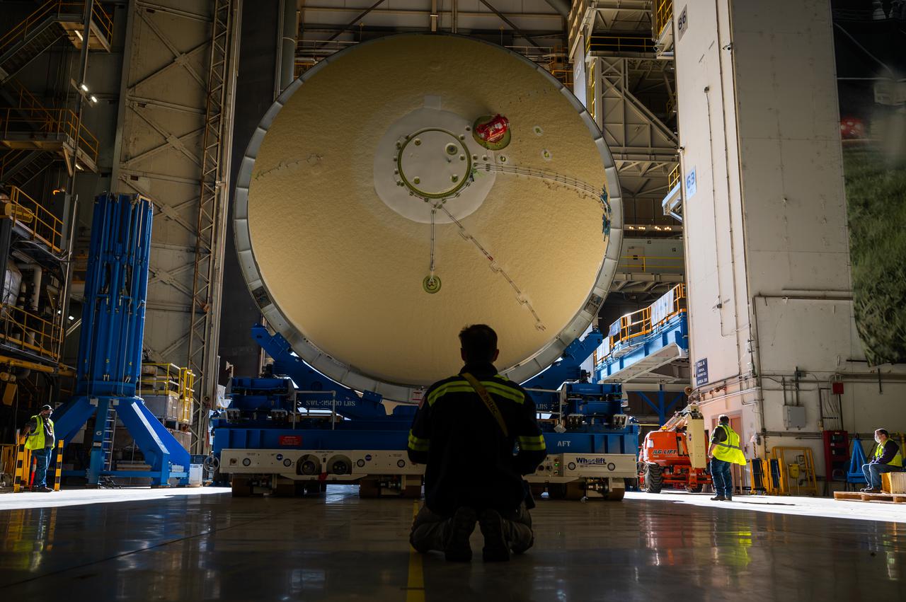 Technicians transported the assembled upper part of the Artemis II core stage to the final assembly area inside the factory at NASA’s Michoud Assembly Facility in New Orleans.  On Jan 10, the forward assembly, left was moved next to the Artemis II liquid hydrogen tank, which has been undergoing assembly. Next, Boeing, the lead core stage contractor, will join the forward assembly and the liquid hydrogen tank to complete most of the core stage for the Space Launch System (SLS) rocket that will send the first crew on an Artemis mission. The core stage consists of five major structures that are built, outfitted, and then connected to form the final stage. The forward skirt, liquid oxygen and intertank were connected and tested to form the 66-foot forward assembly. After the forward assembly is joined with the 130-foot liquid hydrogen tank, only the engine section, the fifth piece of the stage, will need to be added to complete the Artemis II core stage.  The core stage serves as the backbone of the rocket, supporting the weight of the payload, upper stage, and crew vehicle, as well as the thrust of its four RS-25 engines and two five-segment solid rocket boosters attached to the engine and intertank sections. On Artemis II, the SLS rocket will launch the Orion spacecraft and a crew, sending them into lunar orbit, in preparation for later Artemis missions that will enable the first woman and first person of color to land on the Moon.